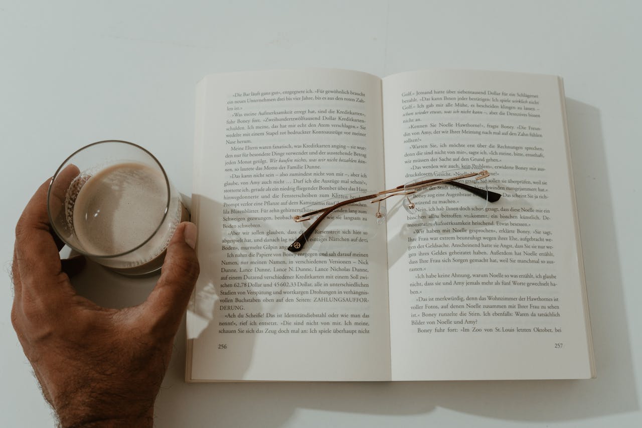A serene moment with a book, glasses, and coffee in a Berlin café.